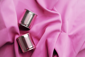 Fototapeta na wymiar Tin can on pink silky fabric, aesthetic concept