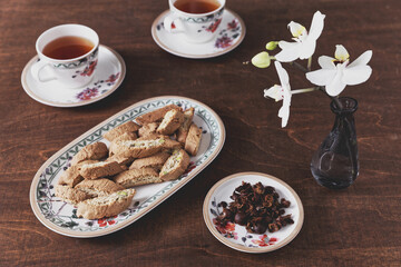 Cup with cascara coffee cherry tea and cantuccini cookie biscuits on a plate.