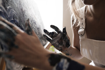 Woman painting with fingers close up 