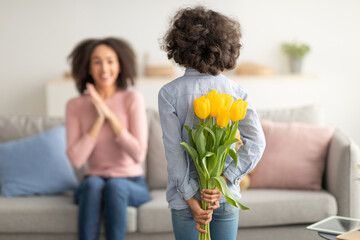 Black girl celebrating mother's day, greeting woman with tulips