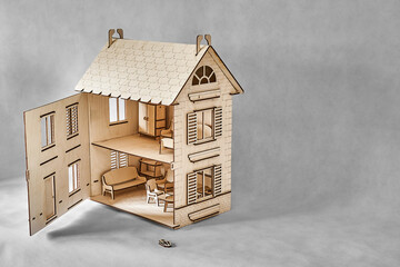Cute doll house with toy furniture made of plywood details cut with laser machine tool stands with open wall on light grey - obrazy, fototapety, plakaty