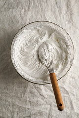 cream meringue, whipped egg whites, whipped cream in a cooking bowl with a whisk