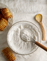 cream meringue, whipped egg whites, whipped cream in a cooking bowl with a whisk