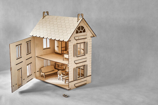 Cute doll house with toy furniture made of plywood details cut with laser machine tool stands with open wall on light grey