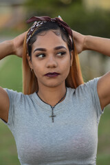 Portrait of young woman with her arms behind her head