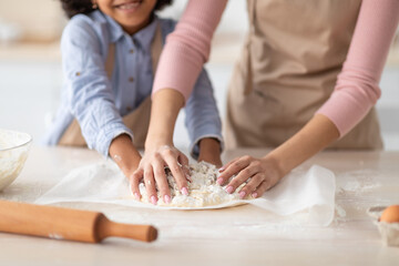 Obraz na płótnie Canvas Closeup of black woman and daughter kneading dough