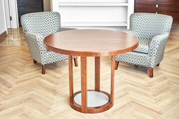 Classic lacquered coffee table made of brown veneer and solid walnut with acrylic part near soft armchairs in living room