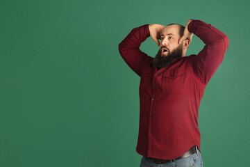 Handsome caucasian man portrait isolated on green studio background with copyspace