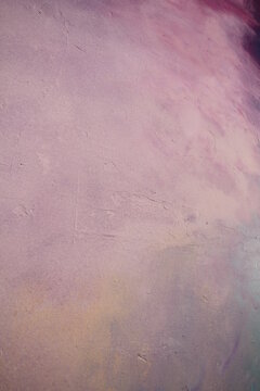 An old painted plaster wall , shades of purple, lilac and blue make an abstract background