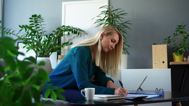 Beautiful woman working at home doing paperwork