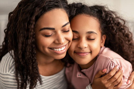 Closeup portrait of black mother and daughter hugging