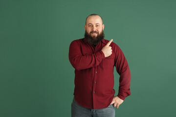 Fototapeta premium Handsome caucasian man portrait isolated on green studio background with copyspace