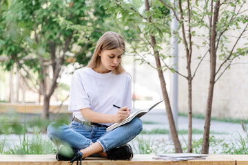 Obraz premium Adult student girl making homework in copybooks