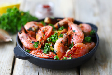 Hot fried prawns in shells with spices in a frying pan.