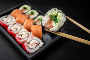 Sushi rolls on black background. Japanese food.