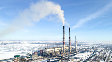 Aerial view of thermoelectric plant with big chimneys in a rural landscape in winter