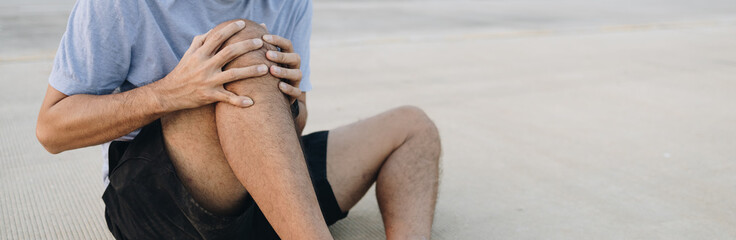 Fototapeta premium Young man sore knee from running with copy space, Knee pain male