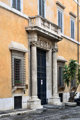 Fototapeta na wymiar monumental entrance to the old house house with stone frame and columns - Rome, Italy