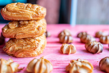 Homemade eclairs and jam puff on a wooden background.