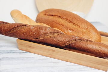 fresh loaves on a breadbasket on the table breakfast kitchen meal