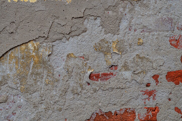 Old wall for texture or background, rough aged surface, remnants of peeling plaster, multi-colored...