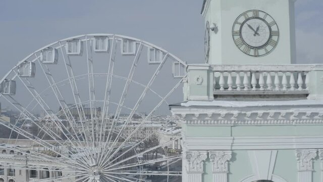 Kiev. Drone video. The big white Ferris wheel and tourists walking in the center of Kontraktova Square in the Podolsk district of Kiev. Winter morning.