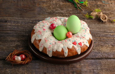 close up of  еaster cake with white icing green eggs  small nest  branch on an old wooden background
with copy  space
