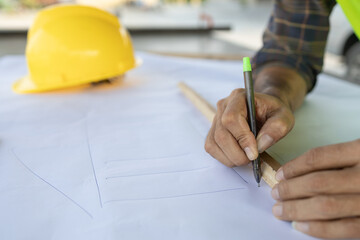 engineer with a construction design pen on a desk with a blueprint