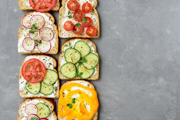 Healthy vegetarian sandwiches with vegetables - yellow pepper, tomato, cucumber and radish. Cream cheese and microgreens