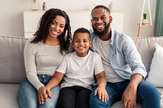Portrait of young happy black family smiling at home