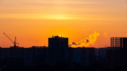 Fototapeta premium sunset over the construction site and the city