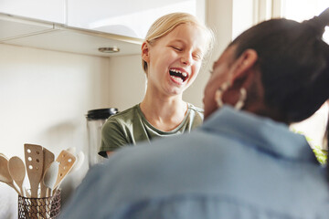 Cute little girl laughing with her mother at home