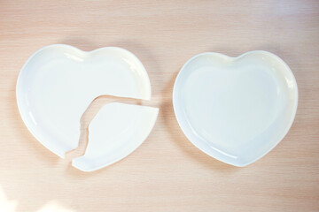 Broken heart-shaped plate. Cracked heart. Shards of broken dishes. Broken plate and whole plate
