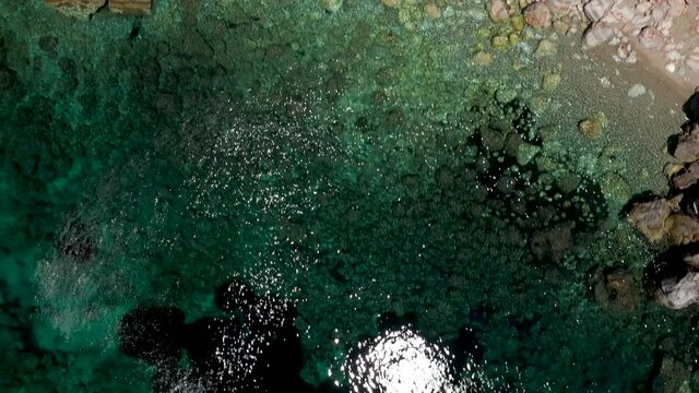 Aerial drone views over a rocky coastline, crystal clear Aegean sea waters, touristic beaches and lots of greenery in Skopelos island, Greece. A typical view of many similar Greek islands.