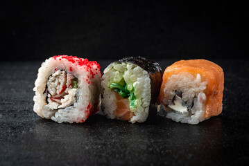 Sushi rolls on black background. Japanese food.