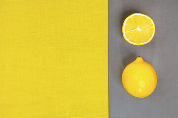 .Trendy Color of the Year 2021. Illuminating Yellow and Ultimate Gray. Lemon fruit on gray background, flat lay.
