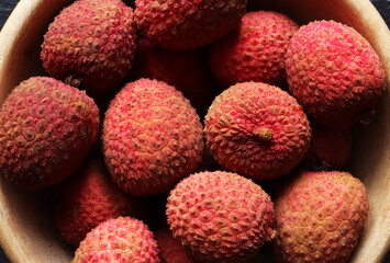 Photograph of many litchies also called lychees  in a wooden bowl for food background