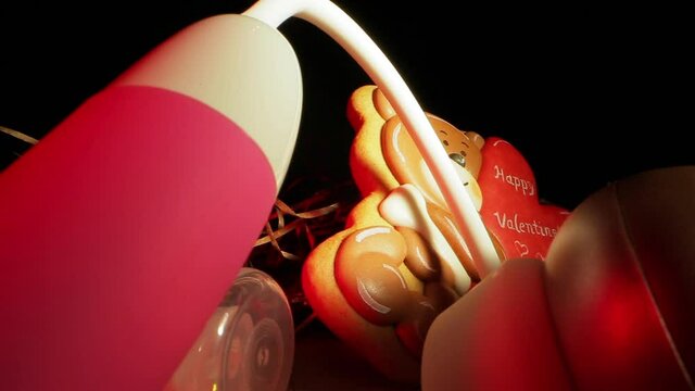 Sex toys lubricant and gingerbread on table in dark room