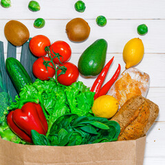Paper bag with different groceries on white background