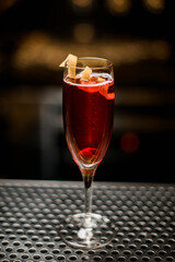 magnificent view on wine glass with red drink decorated with zest on bar