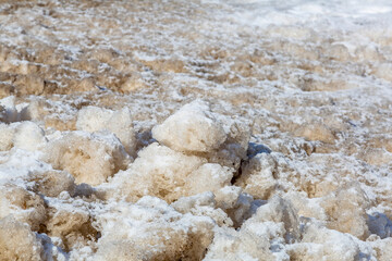 Textured surface of dirty melting snow with ground and soil
