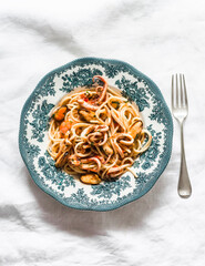 Spaghetti frutti di mare in vintage plate on a light background, top view. Delicious traditional mediterranean food