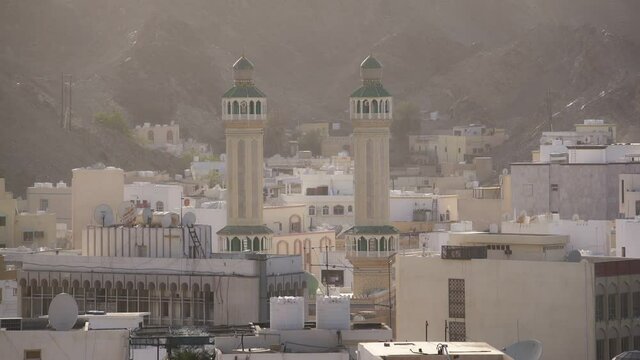 High Muttrah Central Mosque Minarets above Muscat Skyline, Oman - Static wide overview shot