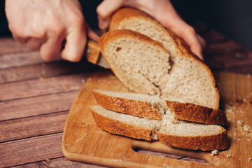 slicing fresh bread on a wooden cutting board breakfast 