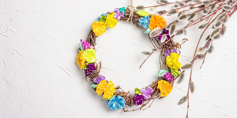 Sprig of willow and braided wreath on white putty texture wall