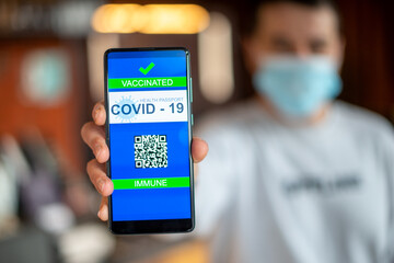 Covid-19 Health Passport. man holding cell phone with qr code covid 19 vaccination.