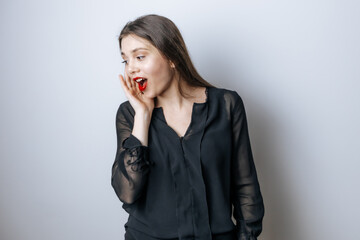 The woman with the red lips opened her mouth in surprise against the light gray background