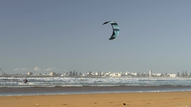 Kiteboarding activity in the waters of Morocco, Essaouira. Kiteboard, surfer, sea, ocean, waves, board, extreme sport, sportsman, summer, vacation / 4K Video Footage