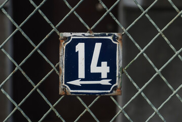 Weathered grunge square metal enamelled plate of number of street address with number 14