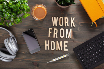 Naklejka premium work from home text desk with keyboard computer smartphone notebook houseplants, workspace office at home